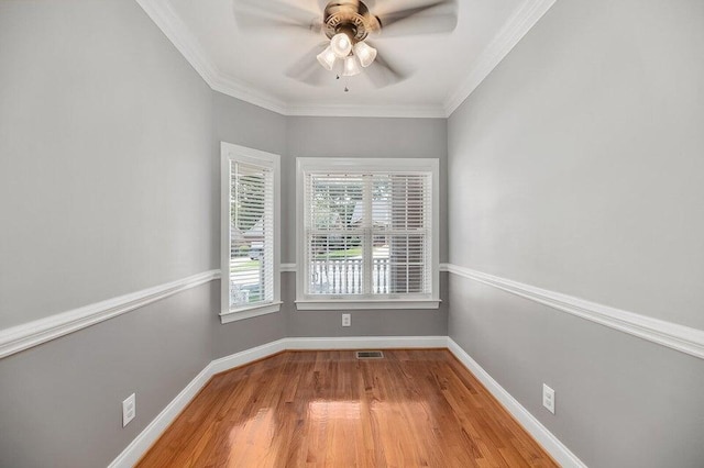 empty room with ornamental molding, hardwood / wood-style floors, and ceiling fan