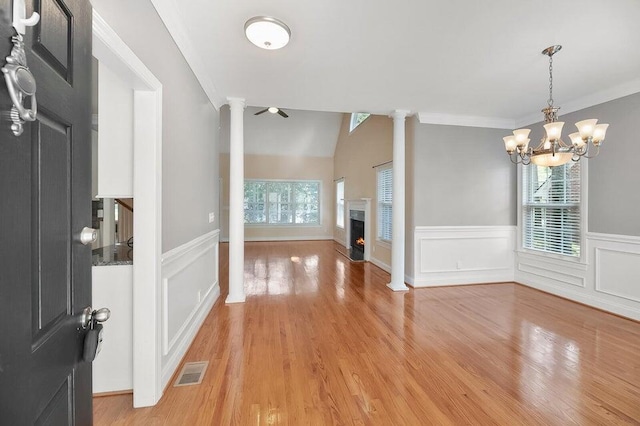 interior space featuring light hardwood / wood-style flooring, a healthy amount of sunlight, and ornate columns