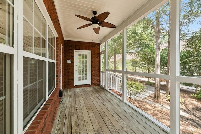 unfurnished sunroom with ceiling fan