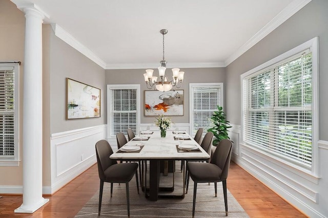 dining area featuring ornamental molding, decorative columns, and hardwood / wood-style floors