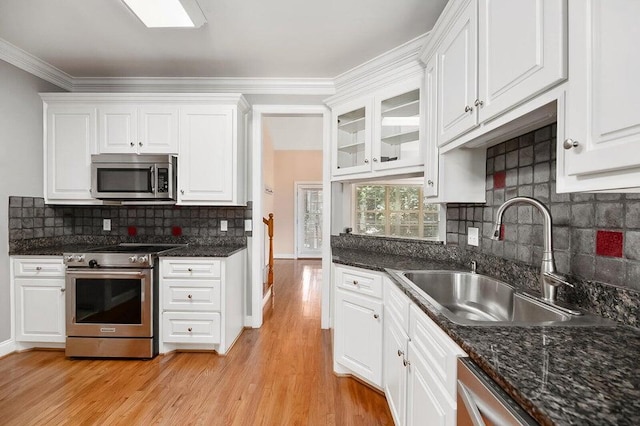 kitchen featuring stainless steel appliances, sink, light hardwood / wood-style flooring, and white cabinets