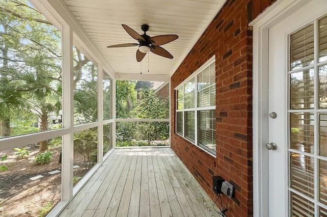 unfurnished sunroom featuring wood ceiling and ceiling fan