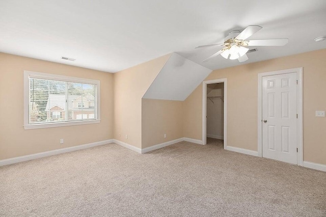 additional living space with ceiling fan and light colored carpet