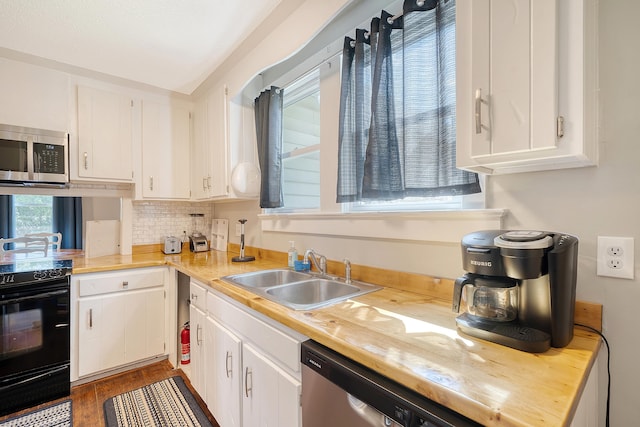 kitchen featuring appliances with stainless steel finishes, white cabinetry, and sink