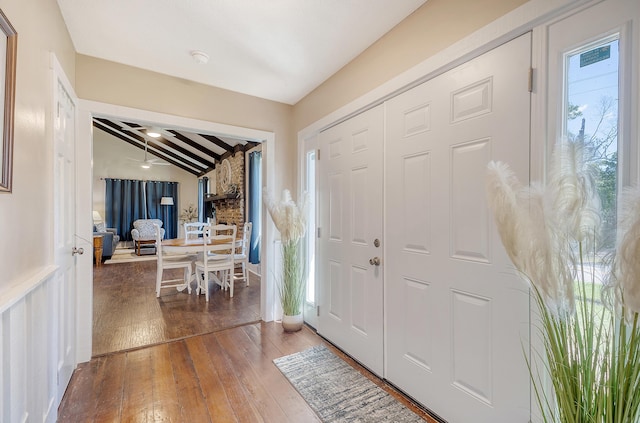 foyer entrance with lofted ceiling with beams and hardwood / wood-style flooring