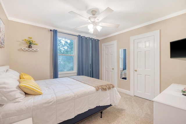 carpeted bedroom with ornamental molding and ceiling fan