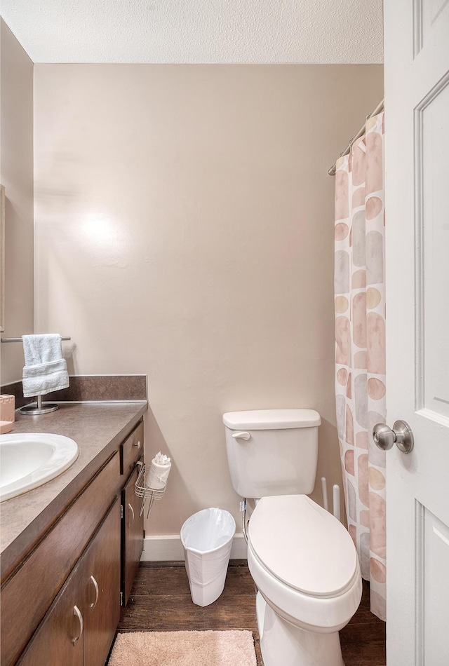 bathroom featuring hardwood / wood-style floors, a textured ceiling, vanity, and toilet