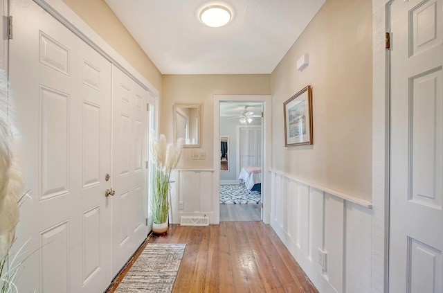 interior space featuring ceiling fan, a textured ceiling, and light wood-type flooring