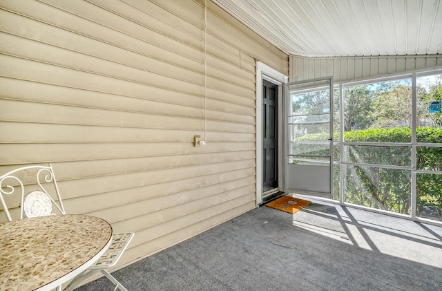 unfurnished sunroom featuring wood ceiling and vaulted ceiling