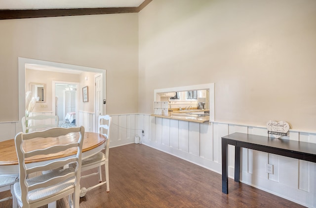 dining area featuring high vaulted ceiling, beamed ceiling, sink, and dark hardwood / wood-style flooring