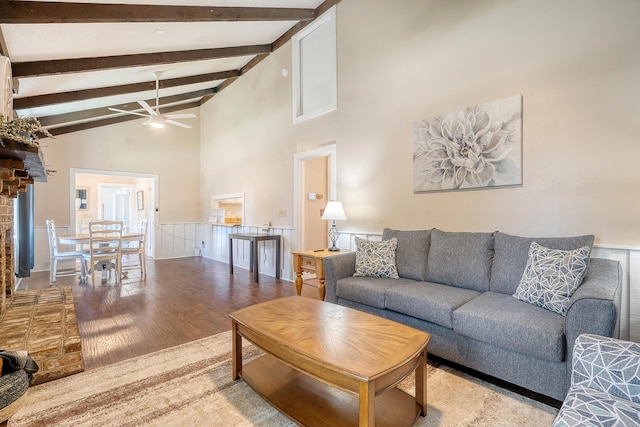 living room with beam ceiling, hardwood / wood-style floors, ceiling fan, and high vaulted ceiling