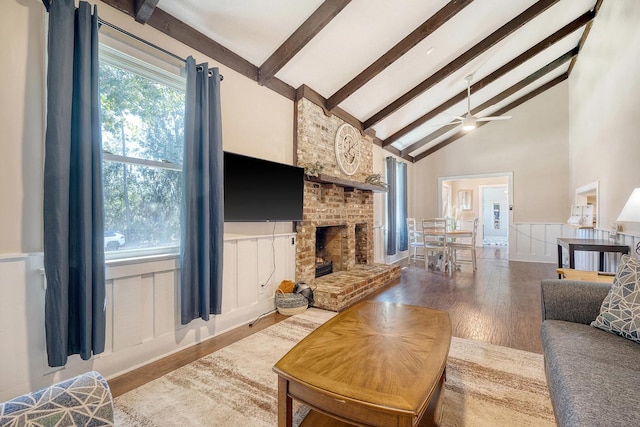 living room with high vaulted ceiling, a brick fireplace, beam ceiling, and hardwood / wood-style floors