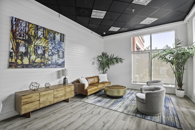 living area featuring a drop ceiling and wood finished floors