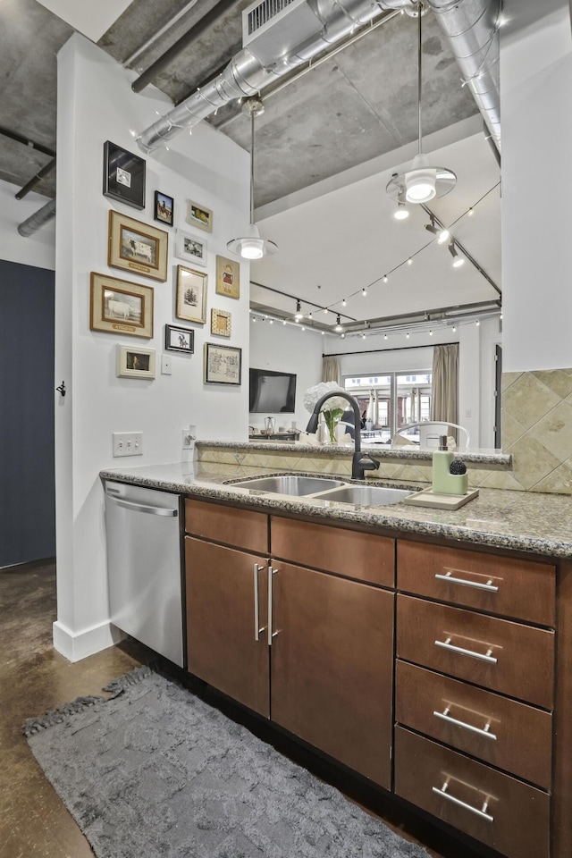 kitchen with a sink, rail lighting, stainless steel dishwasher, and light stone countertops