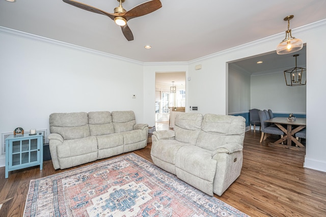 living area with a ceiling fan, wood finished floors, baseboards, ornamental molding, and recessed lighting