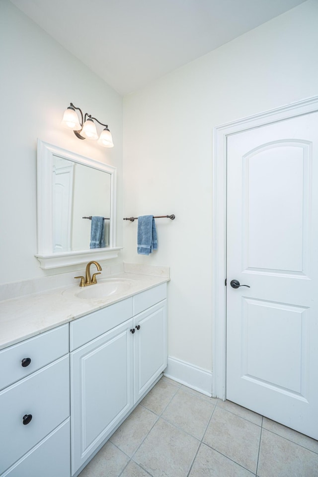 bathroom with vanity, tile patterned flooring, and baseboards