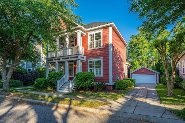 view of front of home with an outdoor structure, ceiling fan, a balcony, and a detached garage