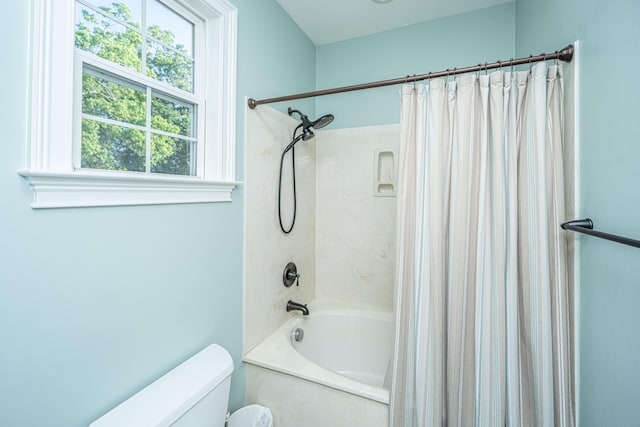 bathroom featuring shower / tub combo with curtain and toilet