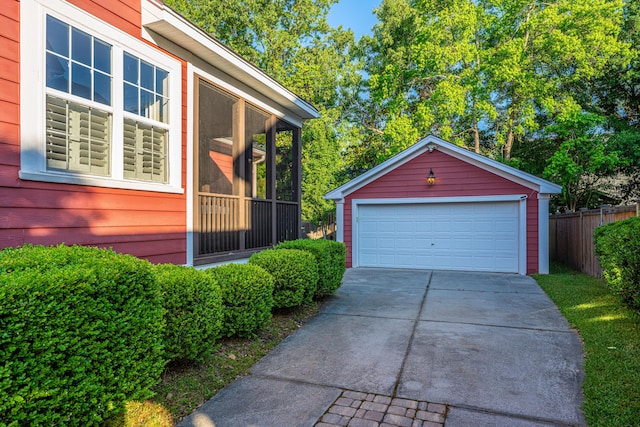 view of home's exterior with a garage, fence, and an outbuilding