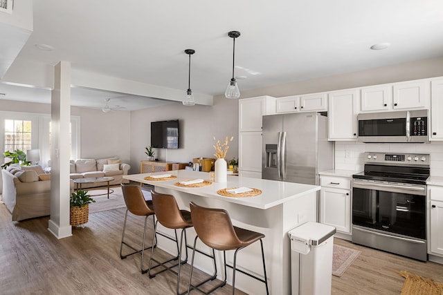 kitchen featuring white cabinetry, a center island, and stainless steel appliances