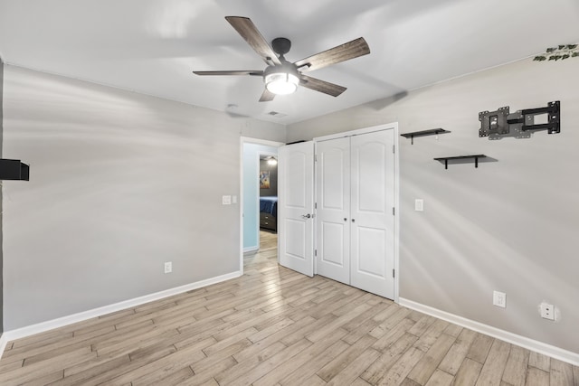 unfurnished bedroom featuring light hardwood / wood-style floors, a closet, and ceiling fan