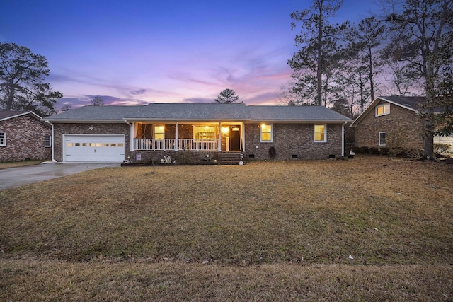 single story home featuring a garage, covered porch, and a lawn