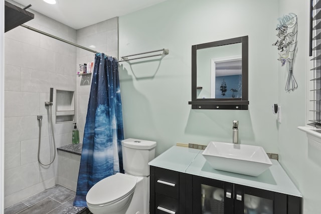 bathroom with toilet, vanity, and walk in shower