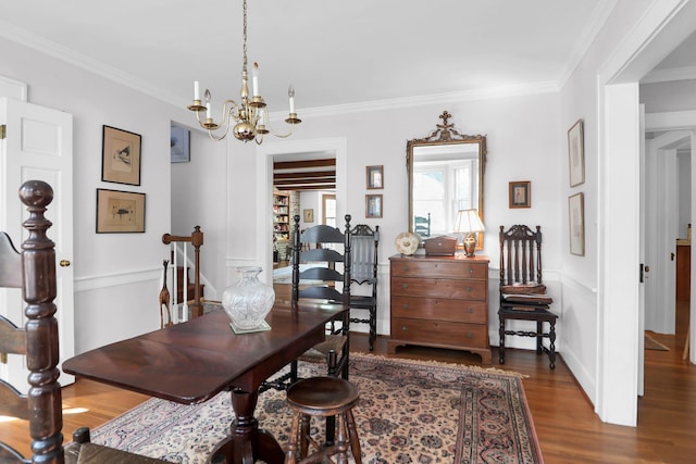 dining room featuring a chandelier, wood finished floors, and crown molding