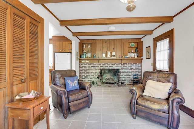 living area with beamed ceiling, a brick fireplace, and light tile patterned flooring