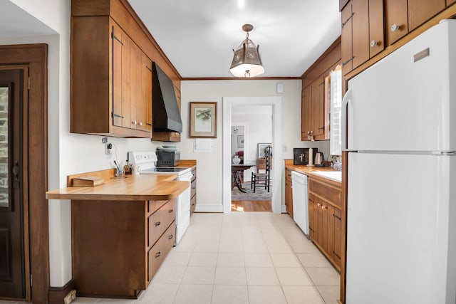kitchen with wall chimney range hood, white appliances, light tile patterned floors, butcher block counters, and baseboards