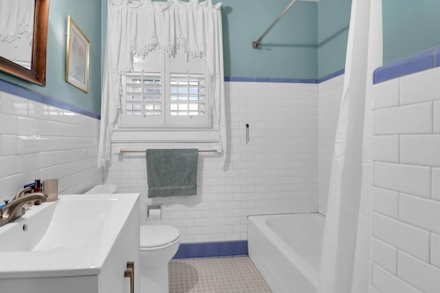 bathroom featuring shower / bath combo, toilet, tile walls, tile patterned flooring, and vanity