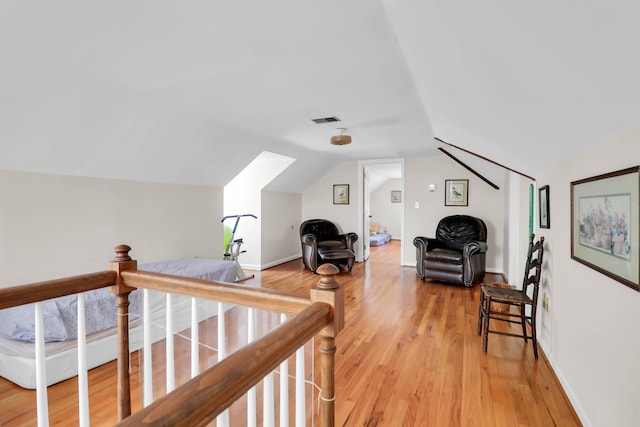 interior space featuring vaulted ceiling, visible vents, baseboards, and light wood-style flooring