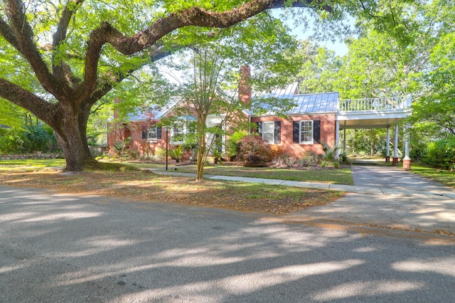 view of front of house featuring driveway, a carport, a standing seam roof, and metal roof