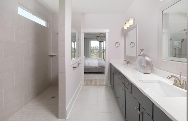 ensuite bathroom featuring ensuite bathroom, a walk in shower, a sink, and tile patterned flooring