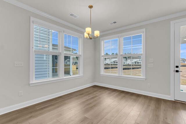 unfurnished dining area with crown molding, visible vents, an inviting chandelier, wood finished floors, and baseboards