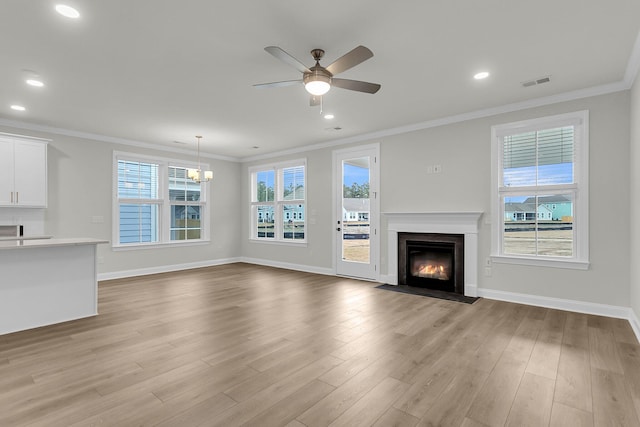 unfurnished living room featuring ceiling fan with notable chandelier, a fireplace with flush hearth, visible vents, baseboards, and light wood finished floors