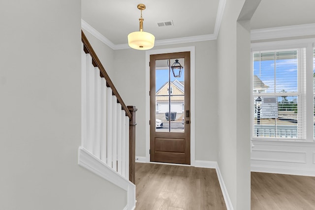 entrance foyer with visible vents, crown molding, and light wood finished floors