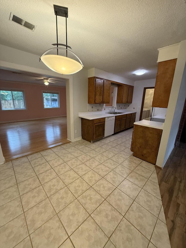 kitchen with white dishwasher, decorative light fixtures, ceiling fan, and a textured ceiling