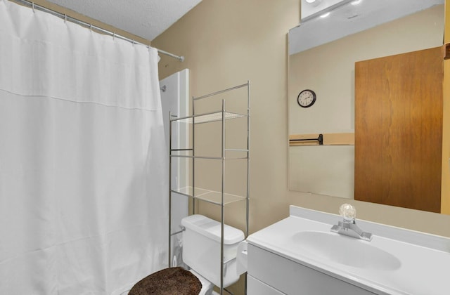 bathroom featuring vanity, curtained shower, toilet, and a textured ceiling