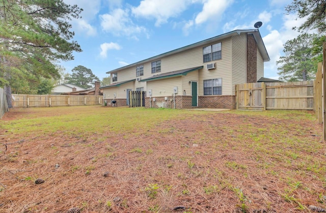 back of house with a wall mounted air conditioner and a lawn