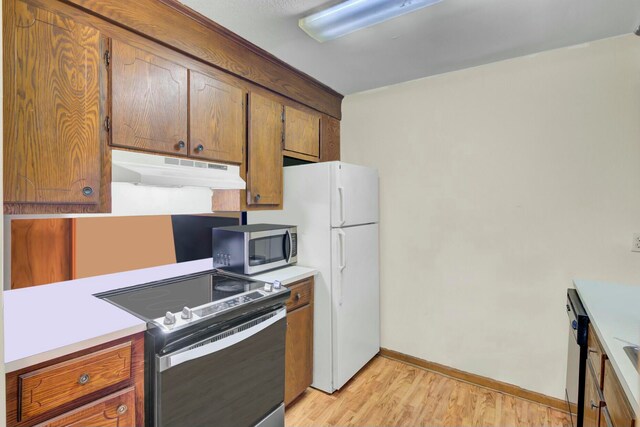 kitchen with light hardwood / wood-style floors and appliances with stainless steel finishes