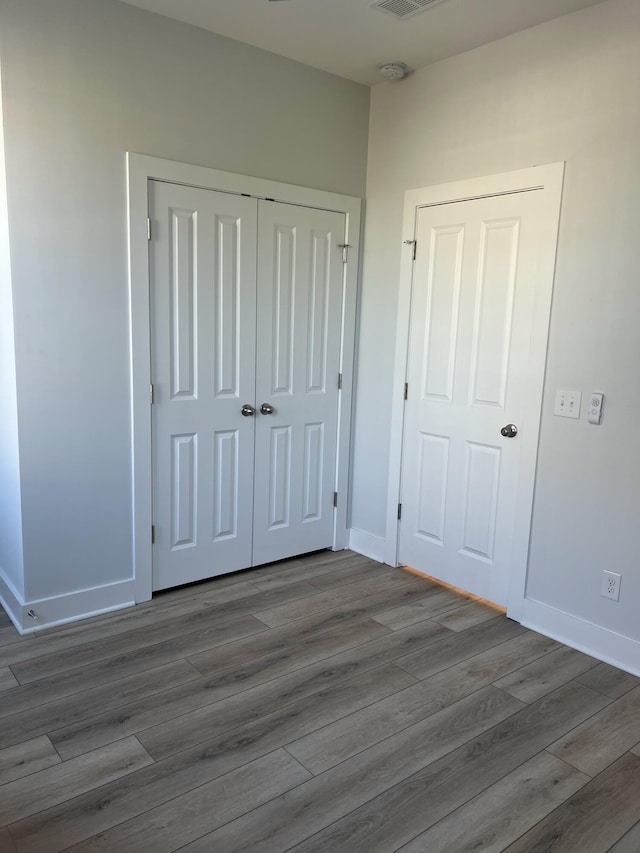 unfurnished bedroom featuring dark wood-type flooring and a closet