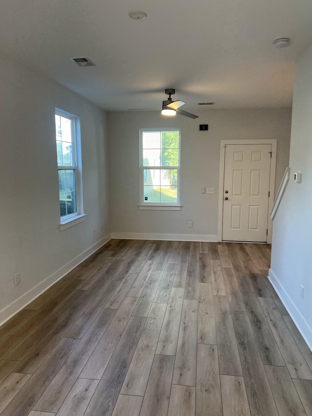 spare room with ceiling fan, plenty of natural light, and light hardwood / wood-style floors