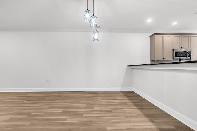 unfurnished dining area with light hardwood / wood-style flooring and crown molding