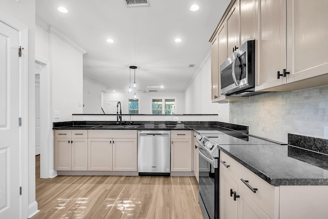 kitchen with sink, ceiling fan, appliances with stainless steel finishes, decorative light fixtures, and light hardwood / wood-style floors