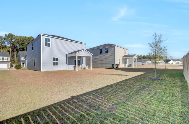 rear view of house featuring a patio and a lawn