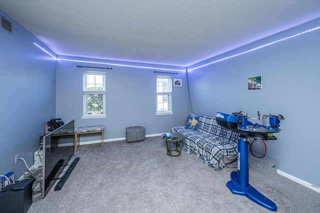 sitting room with baseboards, carpet floors, a textured ceiling, and visible vents