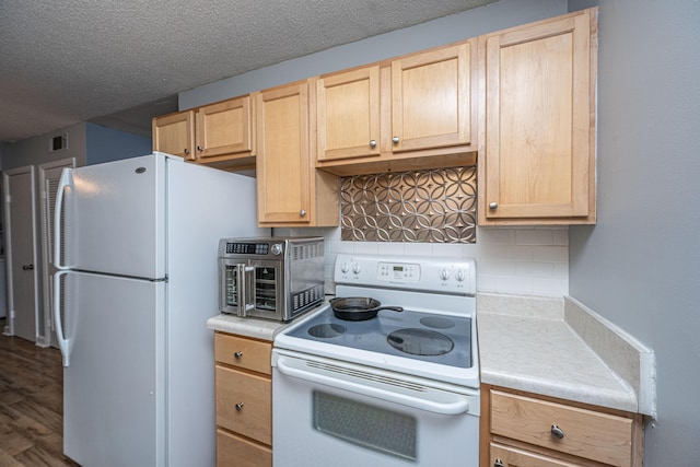 kitchen featuring white appliances, backsplash, light brown cabinets, and light countertops