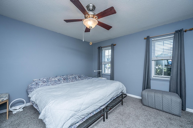 bedroom featuring carpet flooring, a textured ceiling, baseboards, and a ceiling fan