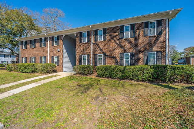 view of front facade with a front lawn and brick siding